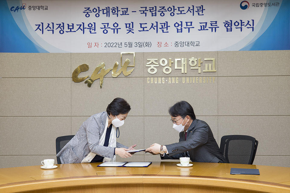 서혜란 관장과 박상규 총장이 협약서를 주고 받고 있다.