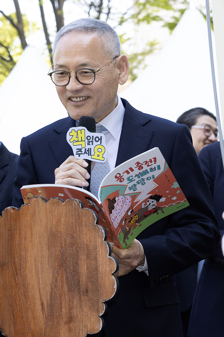 유인촌 문화체육관광부 장관이 국립중앙도서관에서 열린 '2024년 도서관의 날 기념식'에 참석하여 어린이들에게 동화책을 읽어주고 있다.