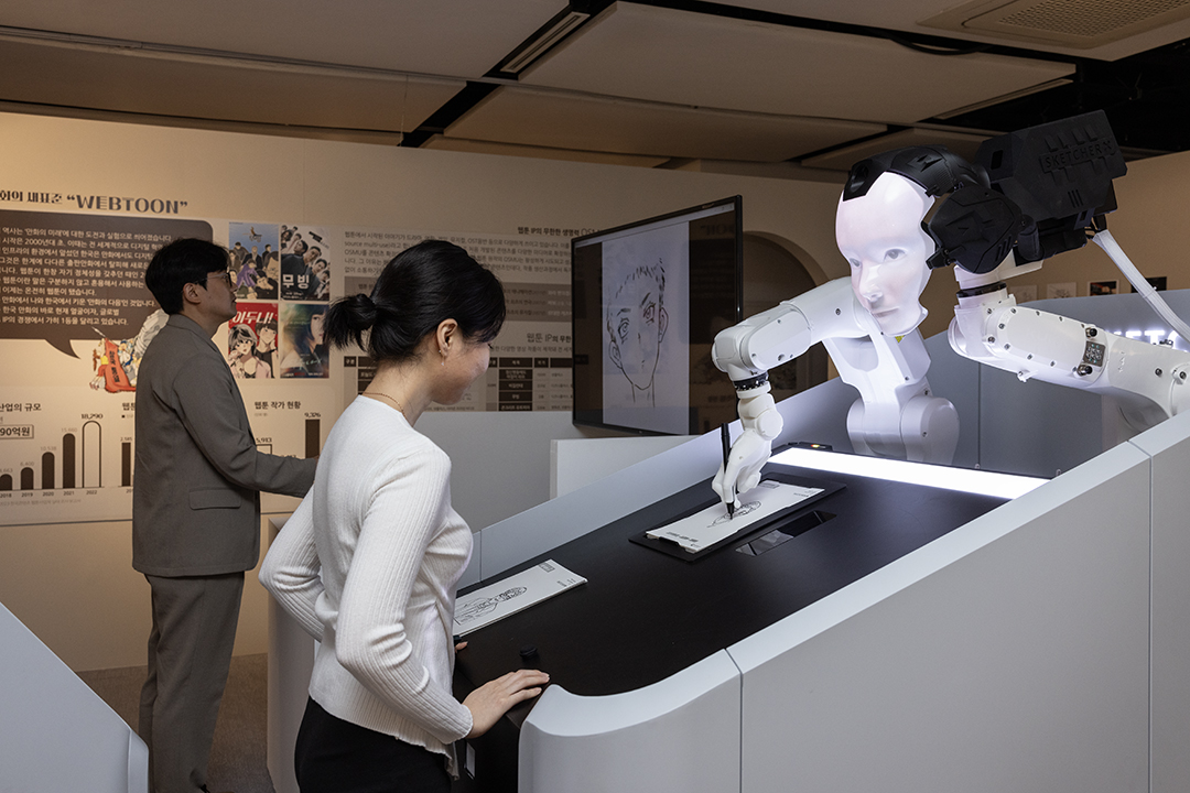 <AI X 이현세>, <AI 로봇 캐리커처>을 체험해 보고 있는 사람들.
