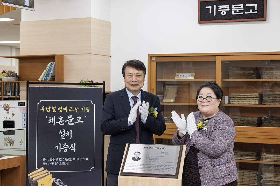 최유진 국립중앙도서관 지식정보관리부장과 부남철 영산대학교 명예교수가 혜훈문고 앞에서 기념촬영을 하고 있다.