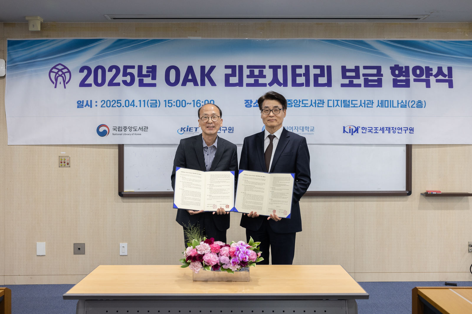 이수명 국립중앙도서관 기획연수부장이 성주석 한국조세재정연구원 경영지원실장과 협약서를 들고 기념촬영을 하고 있다. 
