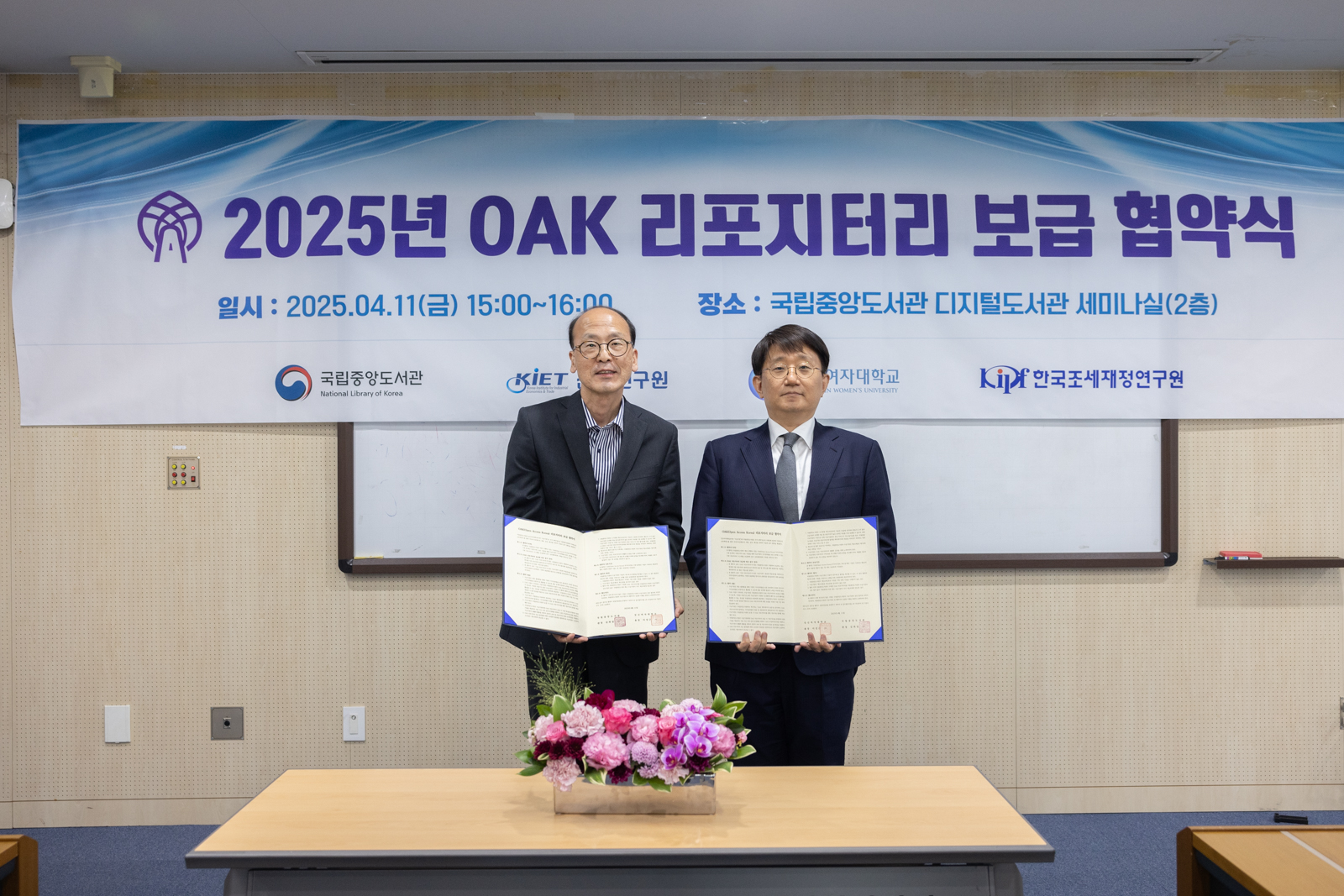 이수명 국립중앙도서관 기획연수부장이 김연식 성신여자대학교 중앙도서관장과 협약서를 들고 기념촬영을 하고 있다. 