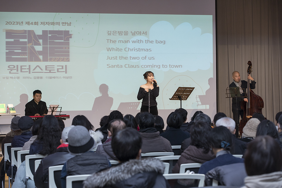 연말에 어울리는 음악들을 선곡한 <이상진 트리오>의 음악공연을 관객들이 즐기고 있다.