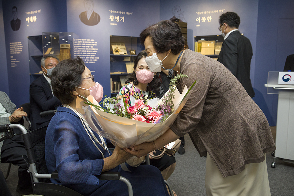 서혜란 국립중앙도서관장이 故서무송 교수의 아내에게 꽃다발을 전달하고 있다.