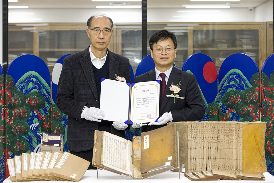 기증증서를 들고 기념촬영하고 있는 조영주 국립중앙도서관 지식정보관리부장과 김주원 한글학회장.