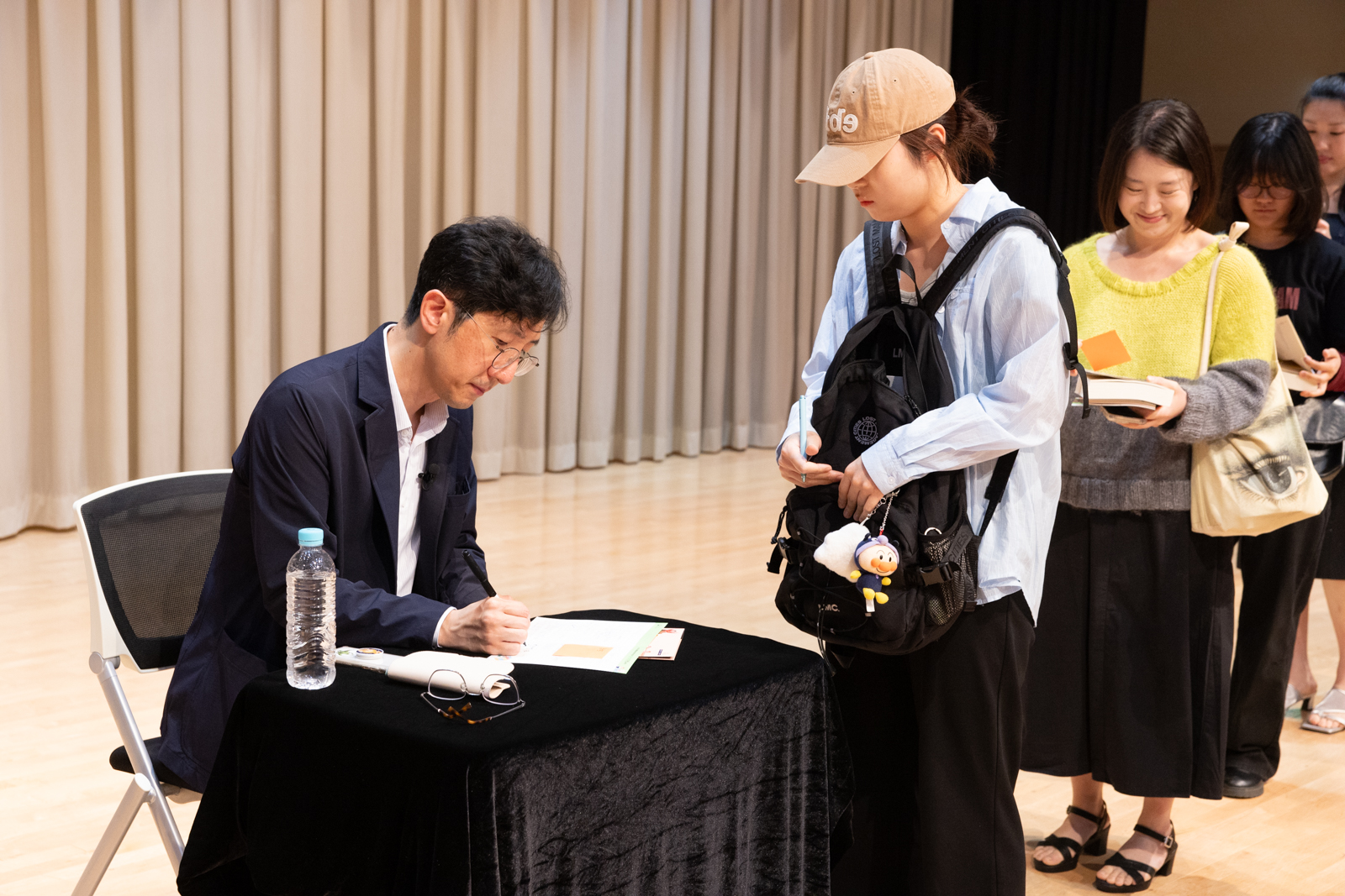[월간 인문학을 만나다_신형철 교수] 사진 : 신형철 교수가 저서에 싸인을 하고 있는 모습